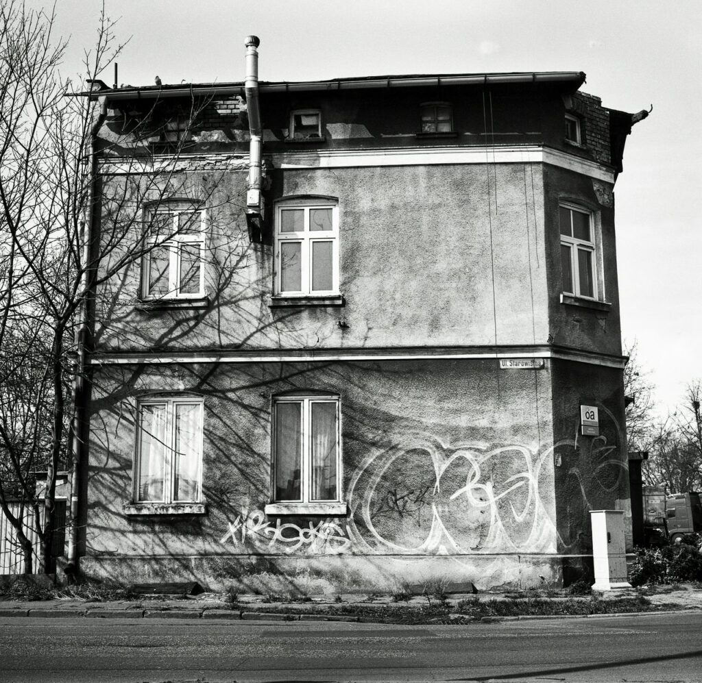 pexels-photo-31364007 A black and white photo of a deteriorating building with graffiti in Gdańsk, Poland.