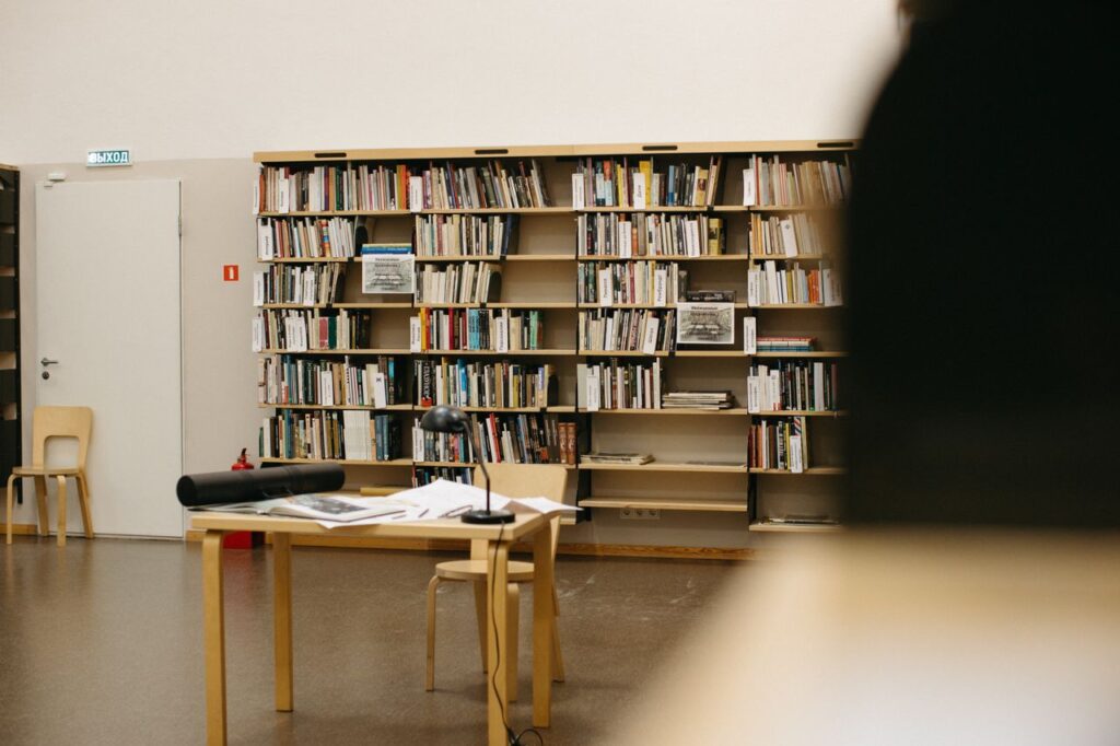 pexels-photo-6279644-1 A serene library space with bookshelves and a study table, inviting for reading and study.